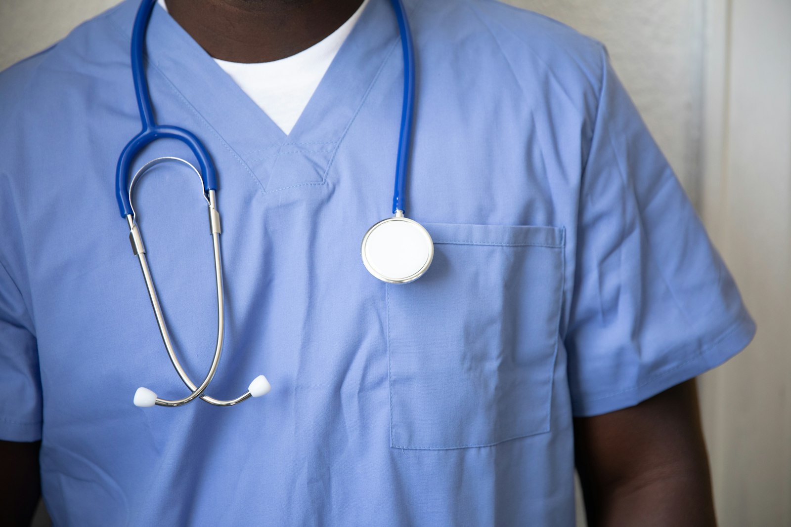 A clinician in scrubs with a stethoscope